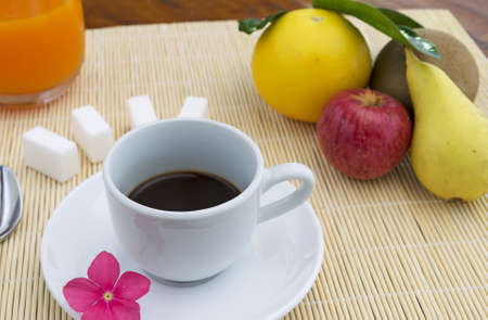 cup of coffee and fruits on a bamboo place matの写真素材