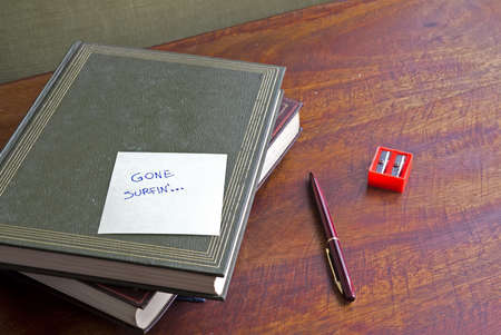 "gone surfing" written on a pile of boring booksの写真素材