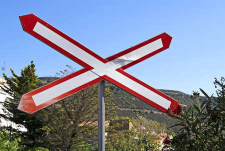level crossing sign under a blue skyの写真素材