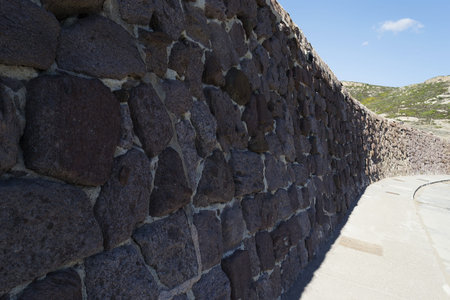close up of a wall made of stones under a blue sky