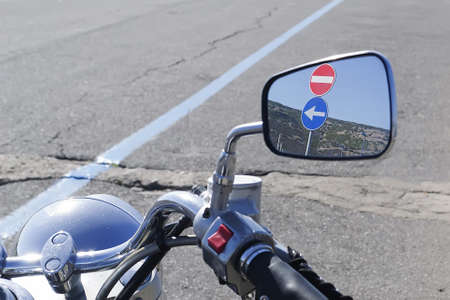 two road signs reflected on a classic bike rearview mirrorの写真素材