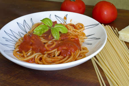 plate of spaghetti with sauce and basilの写真素材