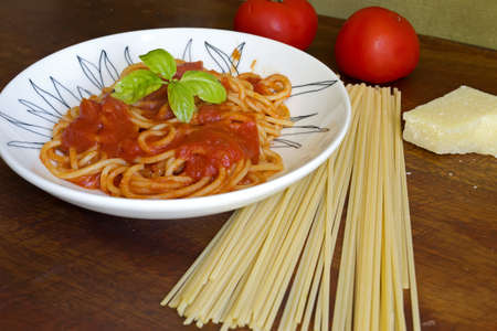 spaghetti with basil and sauce un a ceramic plateの写真素材