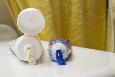 selective focus on two squeezed tubes on a white sinkの写真素材