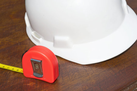 measuring tape and helmet on wooden surfaceの写真素材