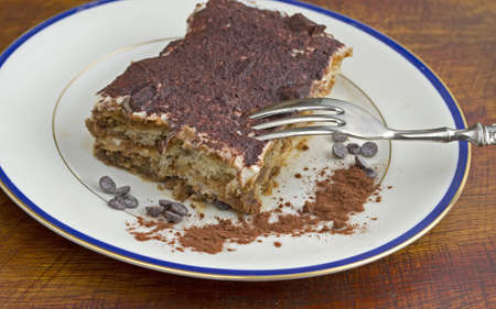 tiramisu dessert in a ceramic plate on a wooden tableの写真素材