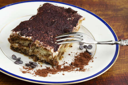 tiramisu dessert in a ceramic plate on a wooden tableの写真素材