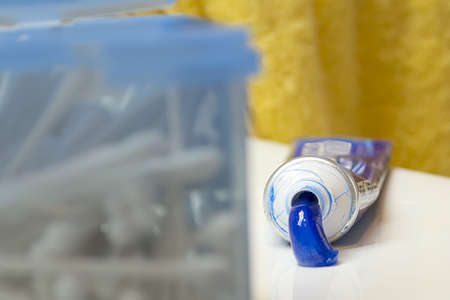 toothpaste tube with a cotton swab box in the foregroundの写真素材