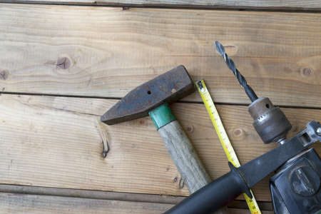 hammer meter and drill on a wooden boardの写真素材