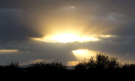 sun going down through cloudsの写真素材