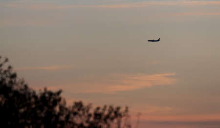 aircraft flying at sunset over the countrysideの写真素材