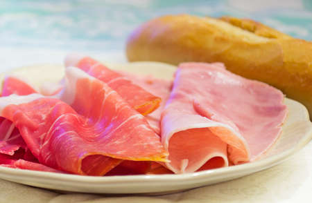 raw ham and ham steak in a ceramic plateの写真素材