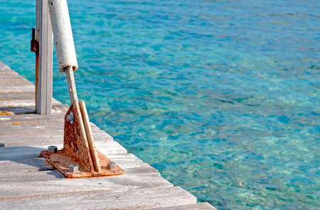 closeup of bolts in a wooden pier over turquoise waterの写真素材