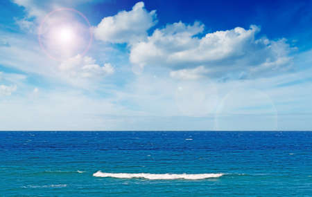 sun glare and waves in Sardiniaの写真素材