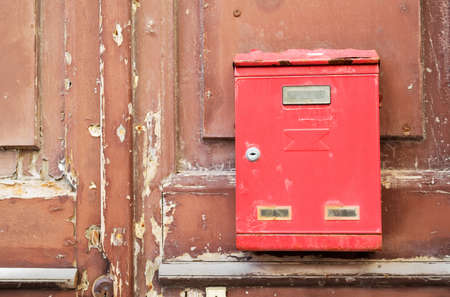old red mailbox on a wooden doorの写真素材