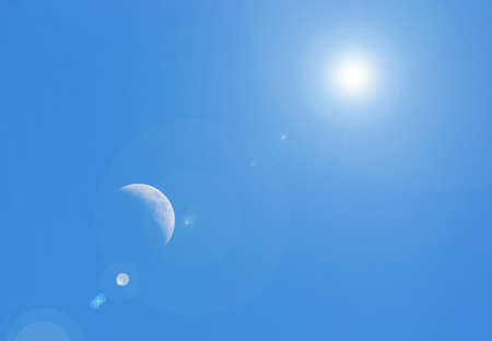 moon in a clear sky under a bright sunの写真素材