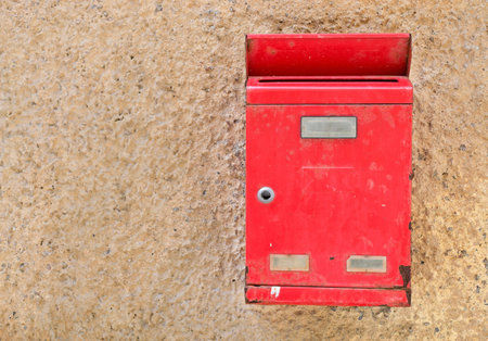 red mail box on a yellow wall