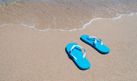 blue flip-flops on the shoreの写真素材