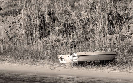 white boat by the shore in sepia toneの写真素材