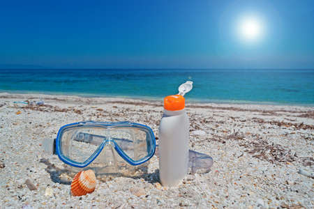 dive mask and suntan lotion at the beachの写真素材