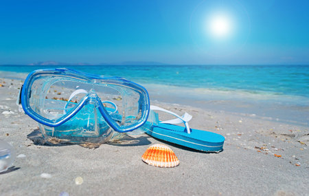 diving mask and shell under a shining sunの写真素材