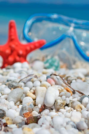 white pebbles with seastar and diving mask in the backgroundの写真素材