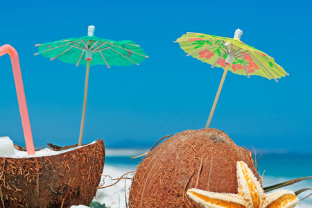 coconuts with straw and parasol on a clear summer day