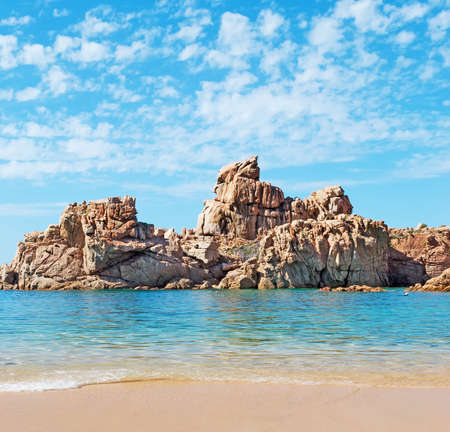 rocks and blue sea under a cloudy skyの写真素材