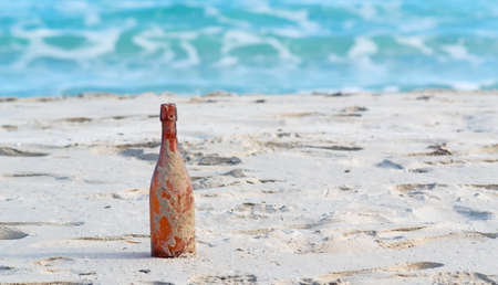 brown bottle stuck in the sandの写真素材