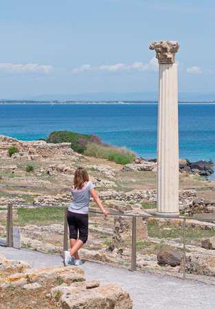 young woman standing in front of Tharros columnの写真素材
