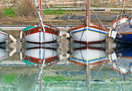 boats reflected in the port waterの写真素材