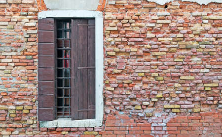 old window in a brick wall in Venice, Italyの写真素材