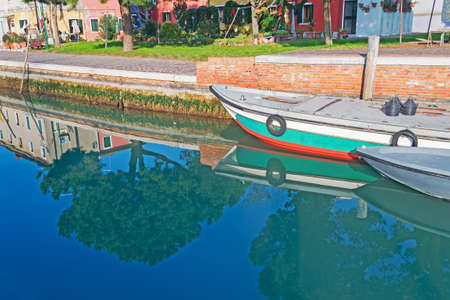 boats and trees reflected in Venice lagoonの写真素材