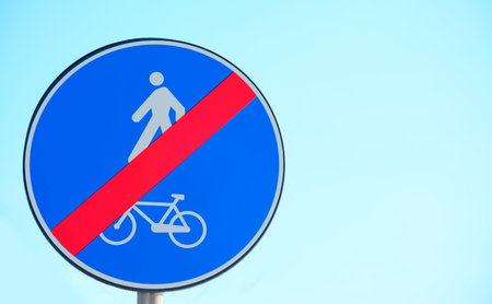 end of bike and pedestrian lane sign under a clear sky