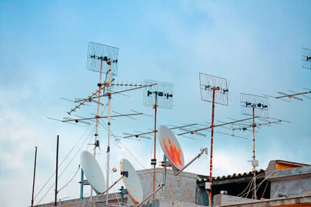 old tv antennas on a building roofの写真素材