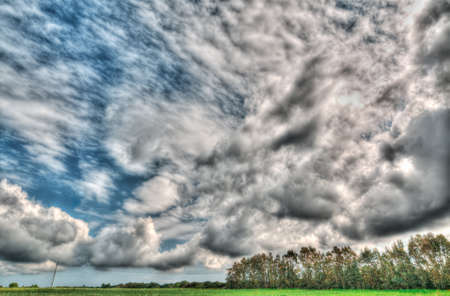 dramatic clouds over a green fieldの写真素材