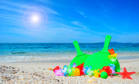 green rackets with hawaiian necklace by the seaの写真素材
