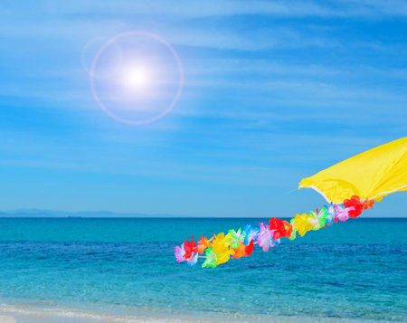 hawaiian necklace swaying in the wind under the sunの写真素材