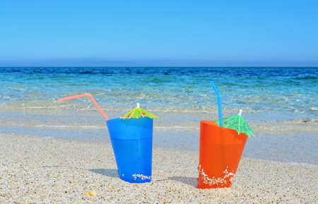 orange and blue drinks by the seaの写真素材