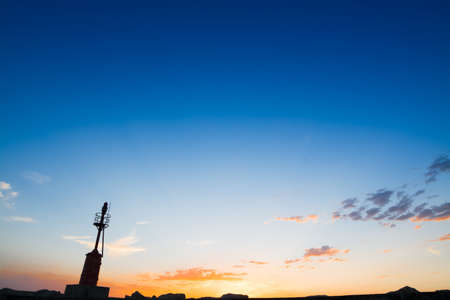 lighthouse silhouette at sunset in Alghero harborの写真素材