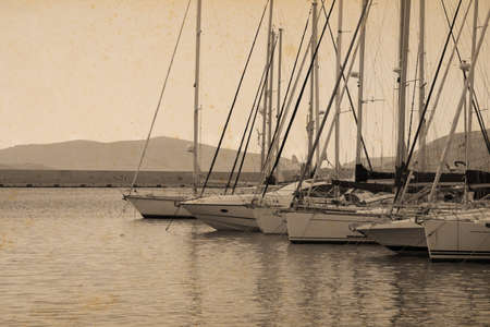 boats in Alghero harbor in vintage tone with stained paper effectの写真素材