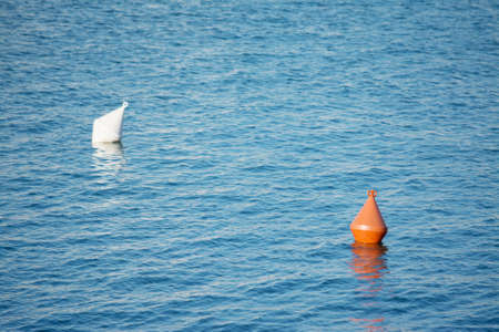 orange and white buoys floating in the seaの写真素材