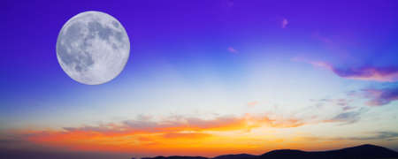 huge moon  in an orange and blue sunsetの写真素材