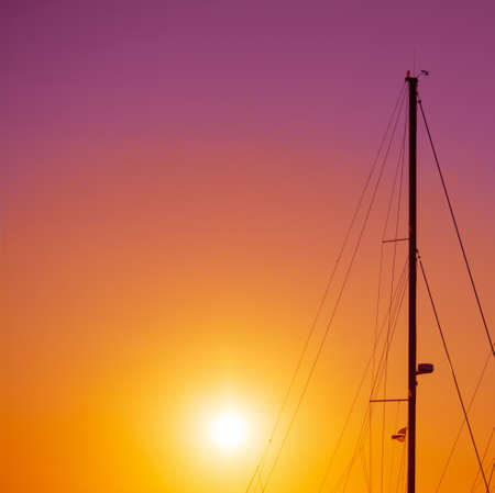 boat mast silhouette under a colorful sunset. Shot in Alghero, Italyの写真素材