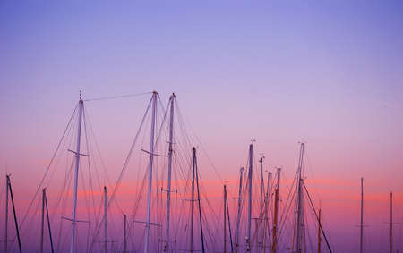 boat masts under a pink and orange sunset. Shot in Alghero, Sardiniaの写真素材