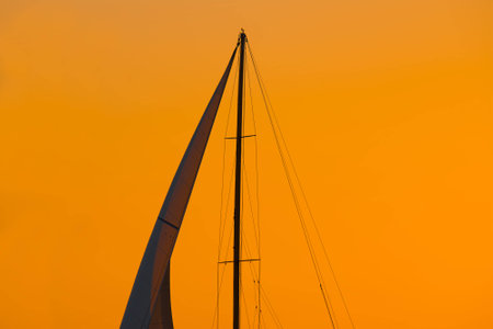 close up of a sail silhouette under an orange sky at sunset. Shot in Alghero, Sardinia.の写真素材
