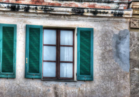 green shutters in a rustic wall. Processed for hdr tone mapping effect.の写真素材