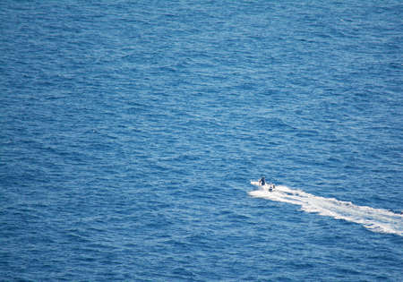 white motorboat sailing in the blue sea. Shot in Capo Caccia, Sardinia.の写真素材