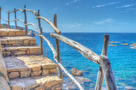 wooden banister by the sea. Processed for hdr tone mapping effect. Shot in Costa Paradiso, Italy.の写真素材