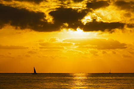 boat at sunset under dark cloudsの写真素材